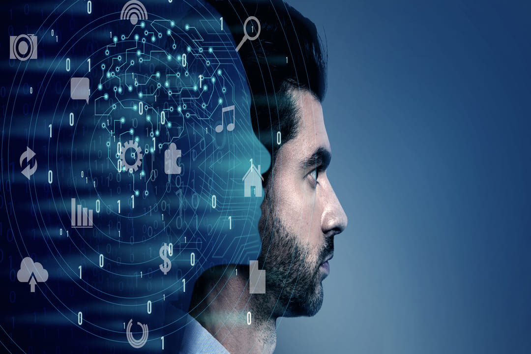 Imagem conceitual de um homem de perfil, com metade de sua cabeça se transformando em um ambiente digital. Do lado esquerdo, há um efeito futurista de circuitos, números binários (0s e 1s) e ícones tecnológicos, como música, casa, engrenagem e nuvem, representando inteligência artificial e tecnologia avançada.